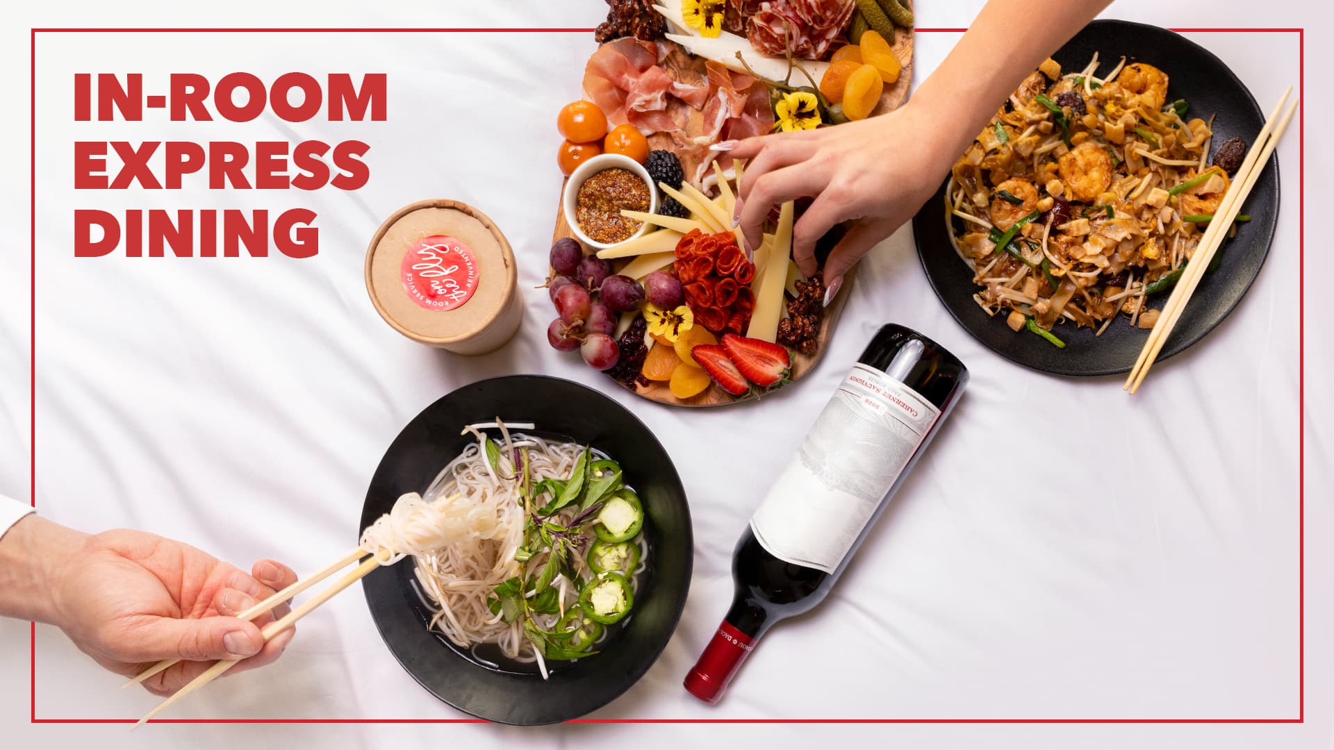 In-room express dining promotion featuring noodle soup, shrimp stir-fry, a charcuterie board, wine, and hands serving food on a white table setting.